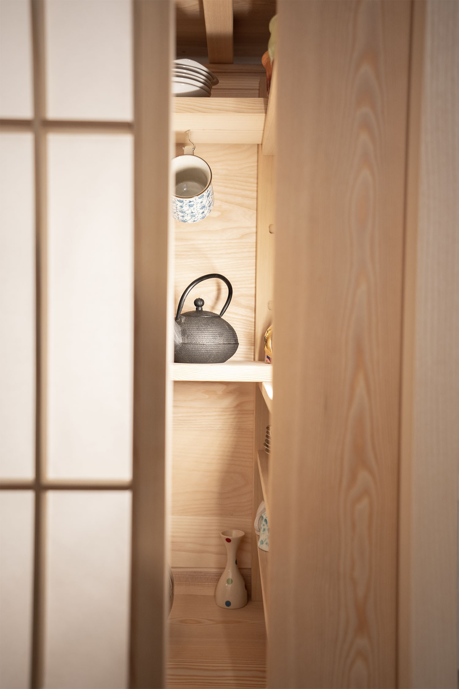 Vista interna della credenza Yatai con anta shoji e ripiani a vista