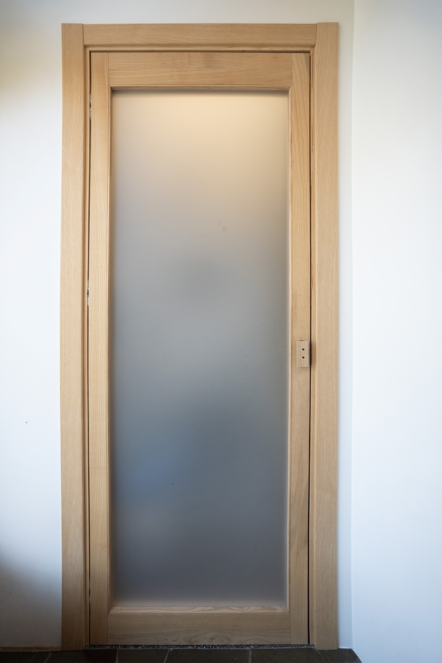 Porta antibagno a telaio in frassino massello con plexiglass bianco opaco