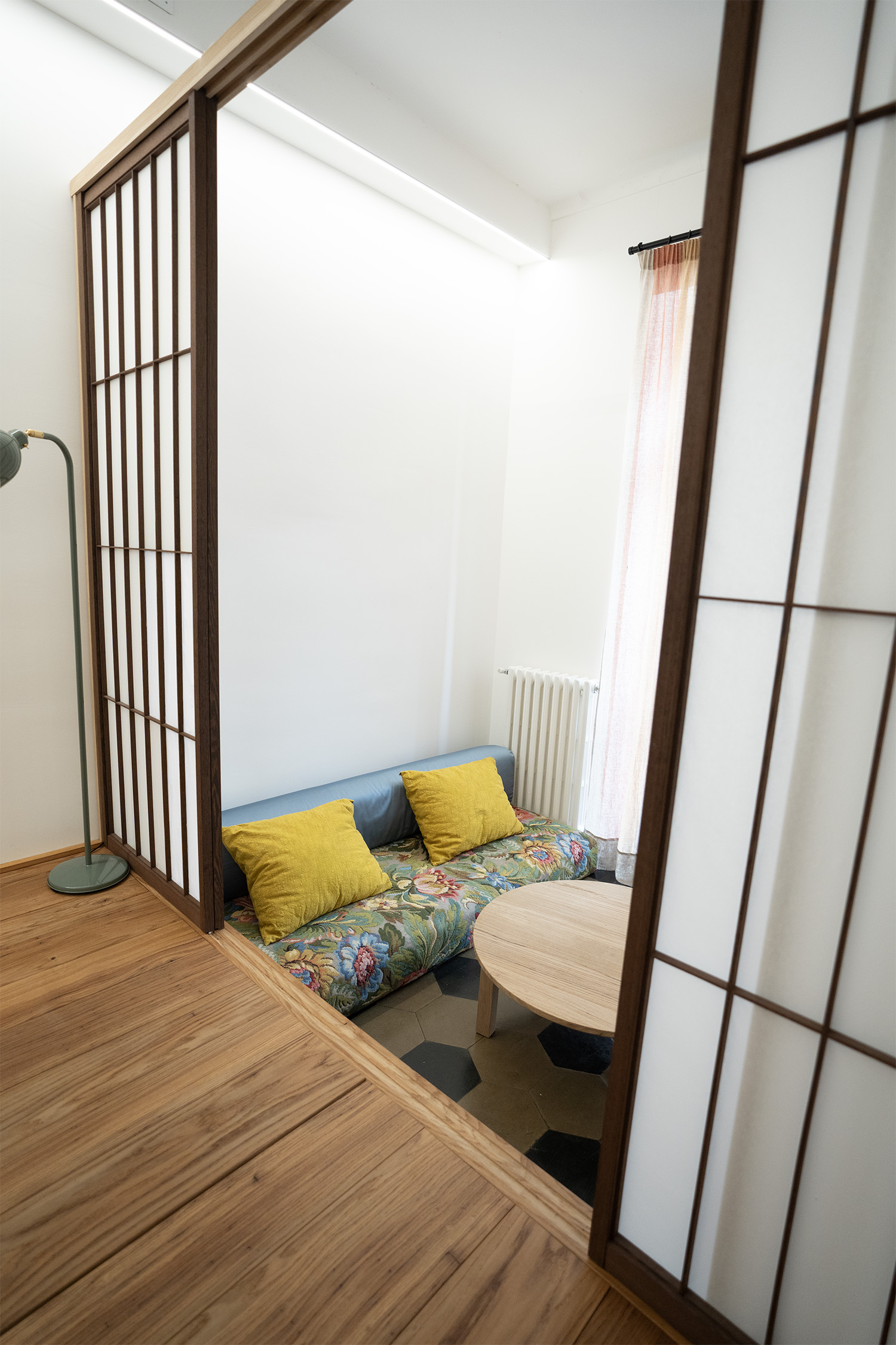 Piattaforma in legno con porte Shoji tra zona giorno e zona notte