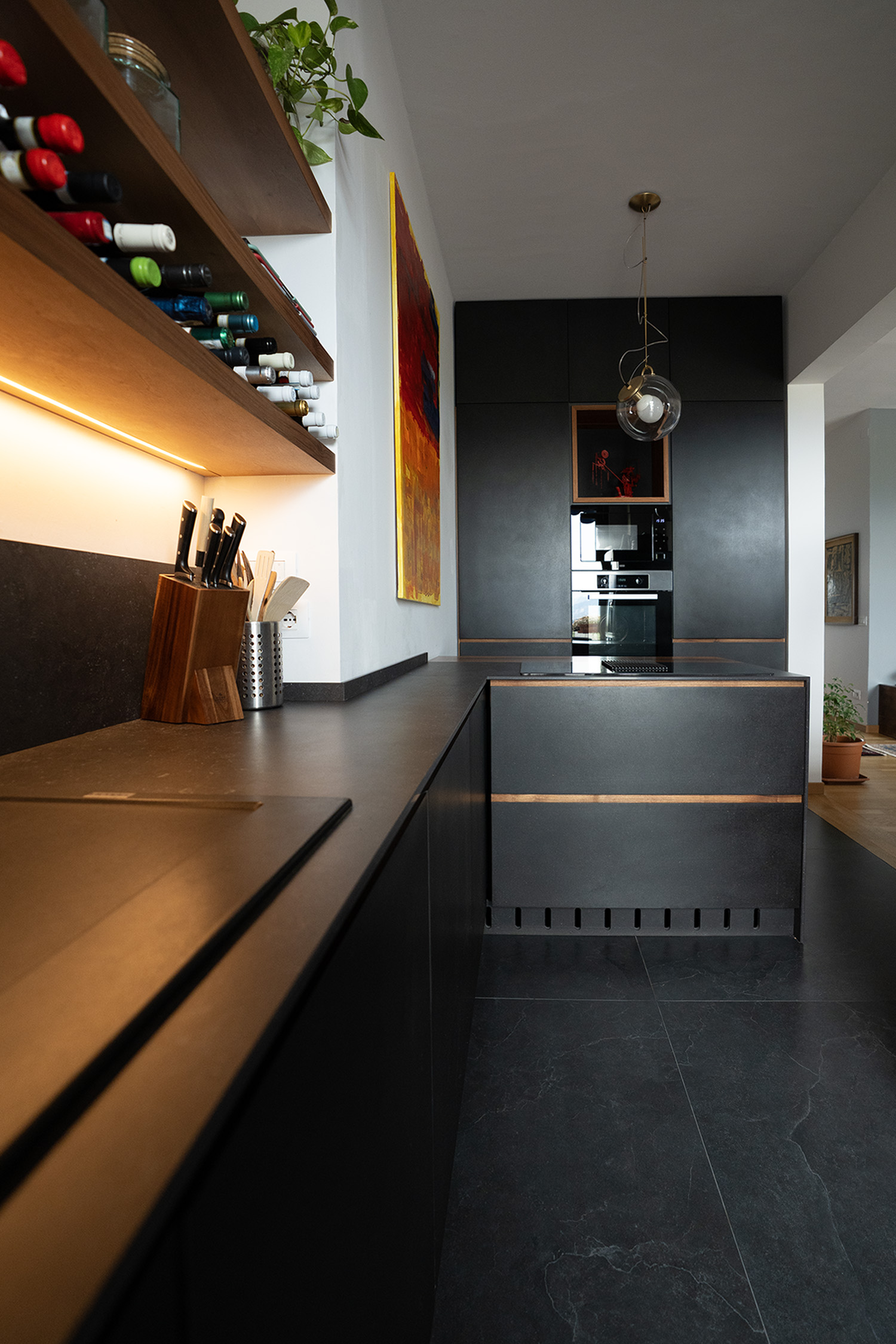 Cucina in noce nazionale e Valcromat con penisola, colonne e mensole in nicchia