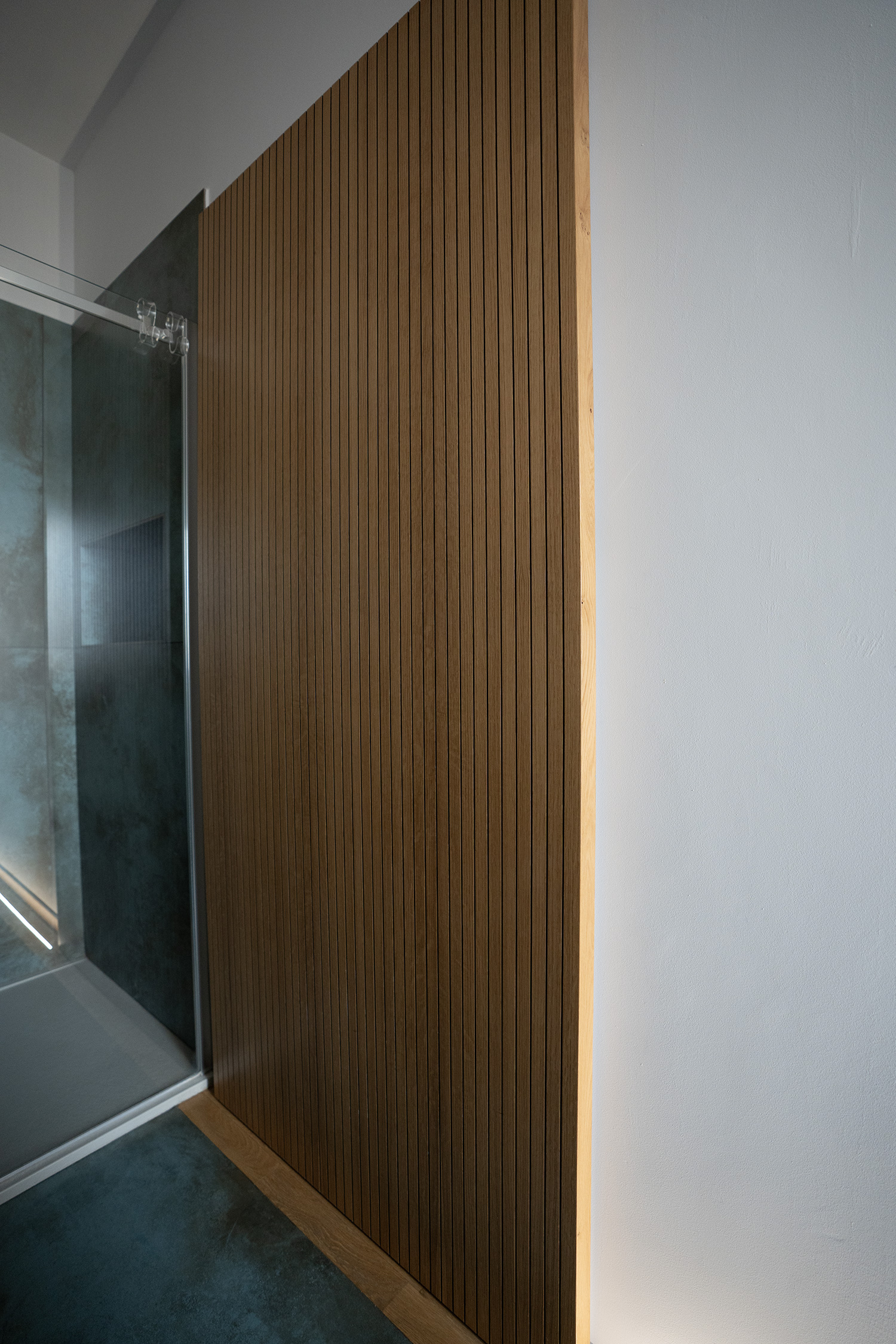 Porta scorrevole in rovere e laccato per accesso al bagno