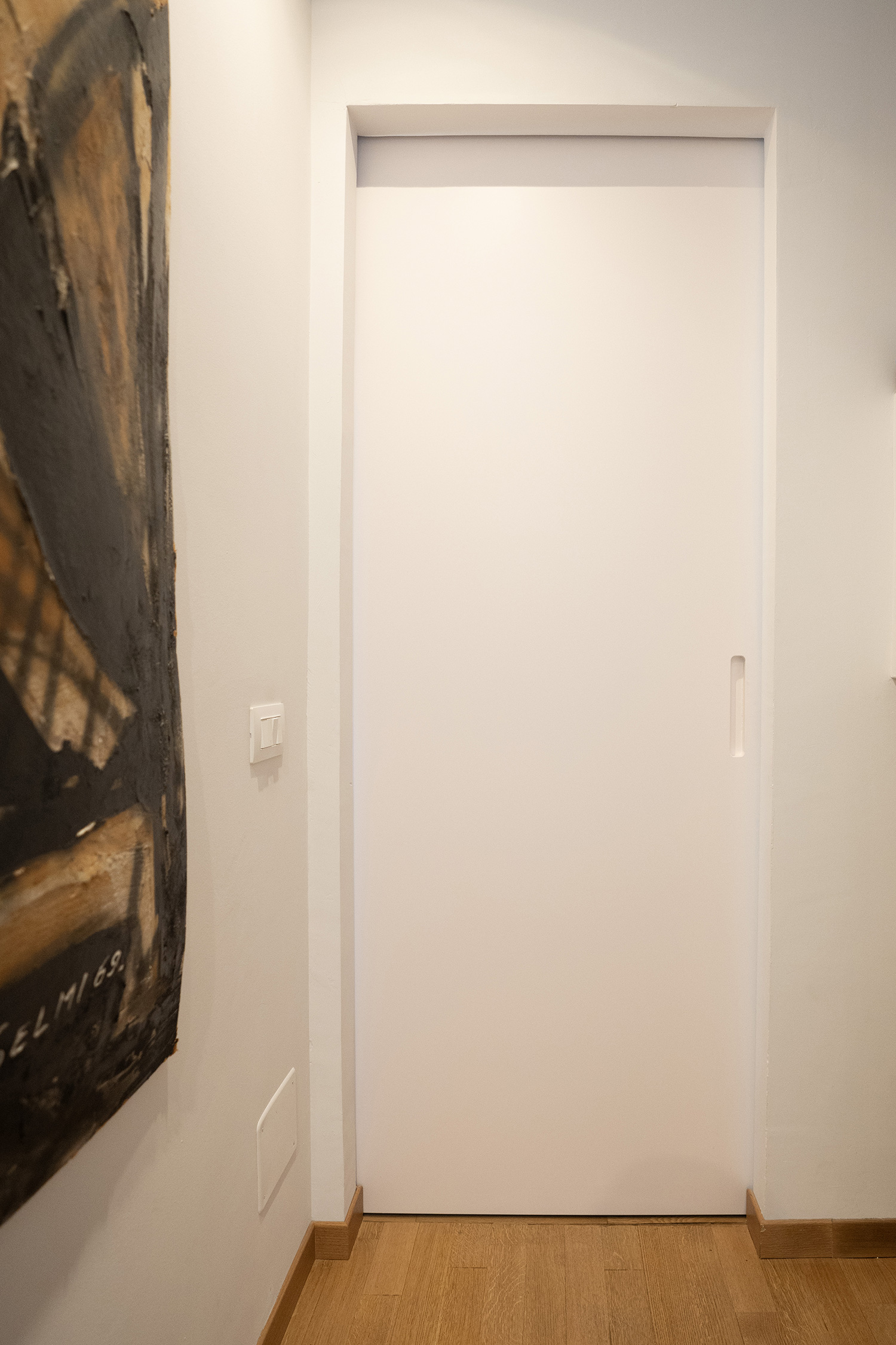 Porta scorrevole in rovere e laccato vista dal corridoio